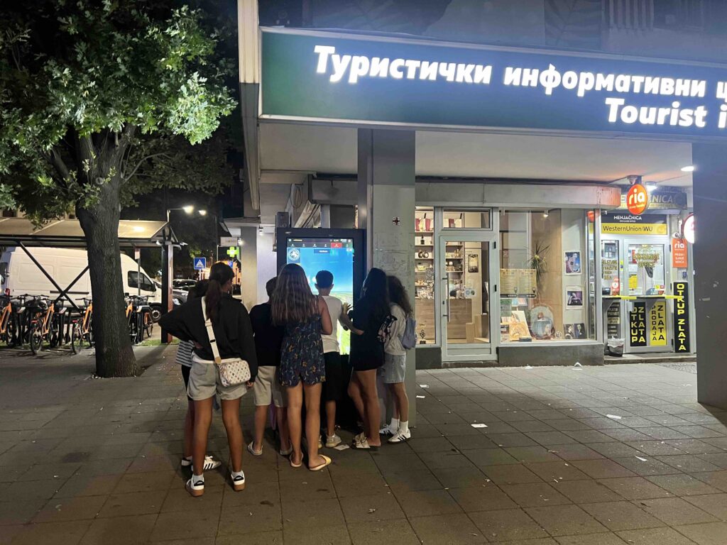 Posetioci koriste interaktivni digitalni displej ispred Turističkog informativnog centra u Požarevcu uveče